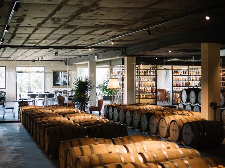 A modern cellar at gin production Gölles, featuring wooden barrels and seating areas. | © David Gölles