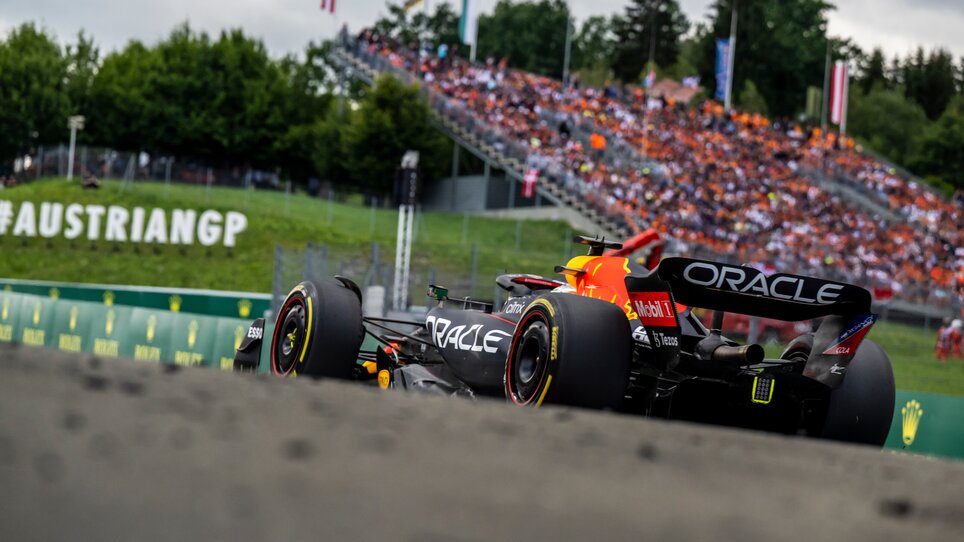 Formula 1 race car speeding on the Red Bull Ring racing circuit, with packed grandstands full of cheering spectators. | © Joerg Mitter - Red Bull Content Pool