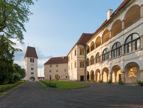 Courtyard of Seggau Castle near Leibnitz with arcades and tower in the evening light. | © Stefan Kristoferitsch