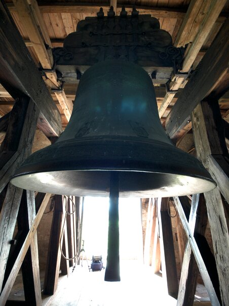 Eine große Glocke in einem hölzernen Glockenturm. | © Schloss Seggau