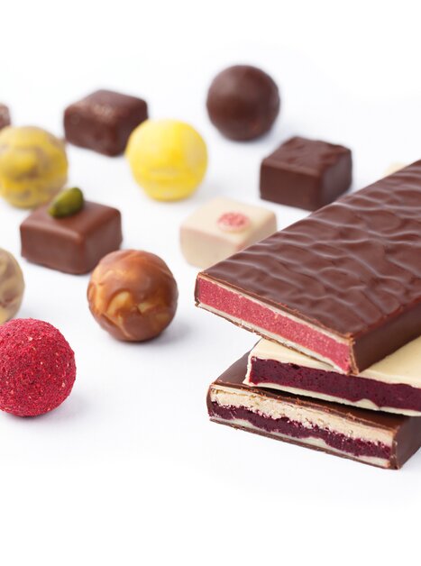 Eine Auswahl an Schokoladen und Pralinen, darunter Zotter Schokolanden und bunte Zotter-Pralinen. | © Zotter Schokolade