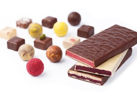 An assortment of chocolates and pralines, including chocolate bars and colorful pralines. | © Zotter Schokolade
