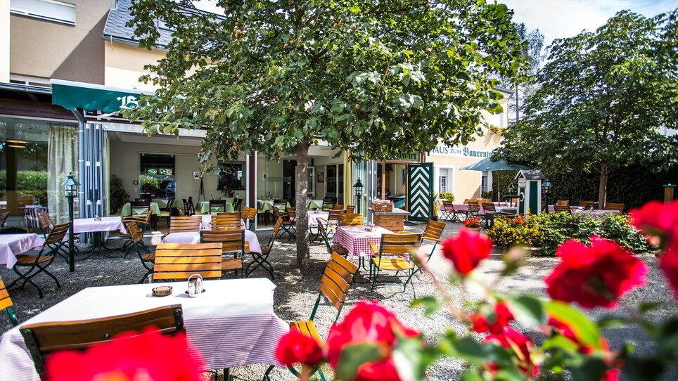 Terrazza del Bauernwirt Graz con tavoli e fiori. | © Rothwangl Photography