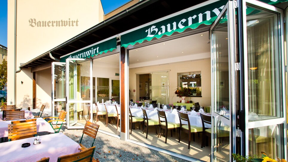 Una vista del ristorante Bauernwirt a Graz con tavoli apparecchiati all'aperto. | © Bauernwirt