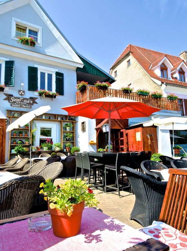 Terrasse des Gasthofs mit Pflanzen und Sonnenschirmen. | © Zur Steirerstubn