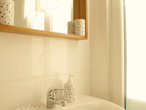 A bright bathroom featuring a sink, mirror, and towels. | © Zur Steirerstubn