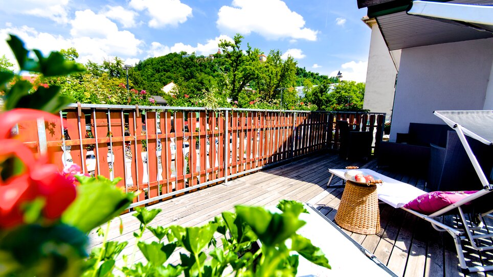 A view of the terrace with flowers and wooden decking. | © Zur Steirerstubn
