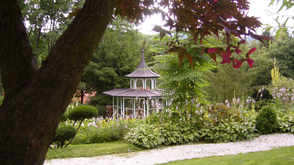 A pavilion surrounded by trees and flowers at Landgasthof Häuserl im Wald. | © Legenstein