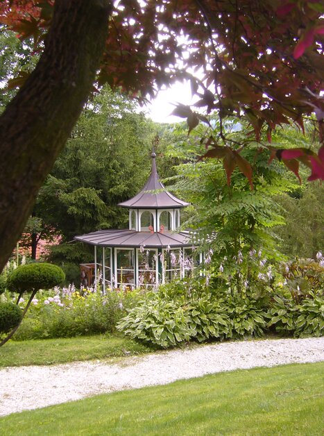 A pavilion surrounded by trees and flowers at Landgasthof Häuserl im Wald. | © Legenstein