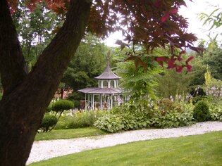 A pavilion surrounded by trees and flowers at Landgasthof Häuserl im Wald. | © Legenstein