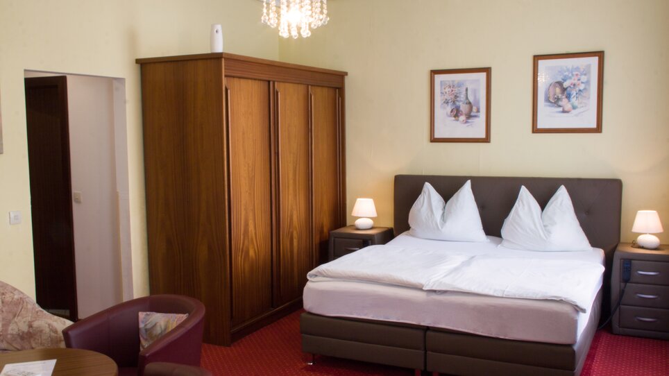 Ein komfortables Zimmer mit Doppelbett, Kleiderschrank und Stühlen. | © Hotel Alter Telegraf