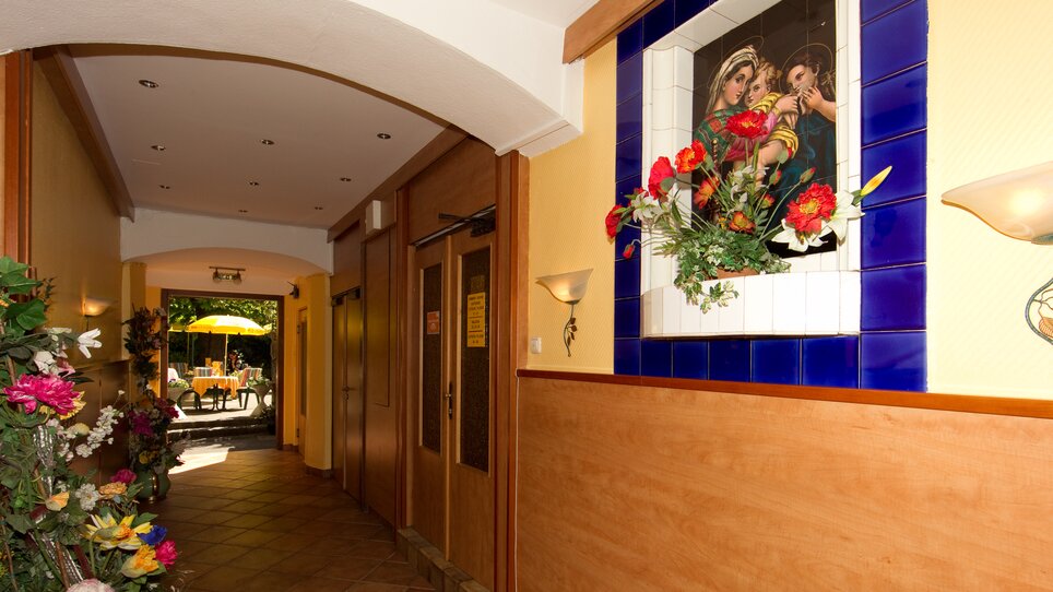 Ein Flur im Hotel Alter Telegraf mit Kunstwerk und Blumen. | © Foto Schmickl