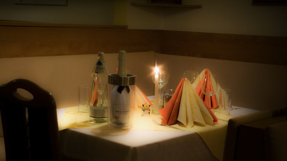Ein gedeckter Tisch mit Kerzenlicht, Flaschen und Servietten. | © Hotel Alter Telegraf