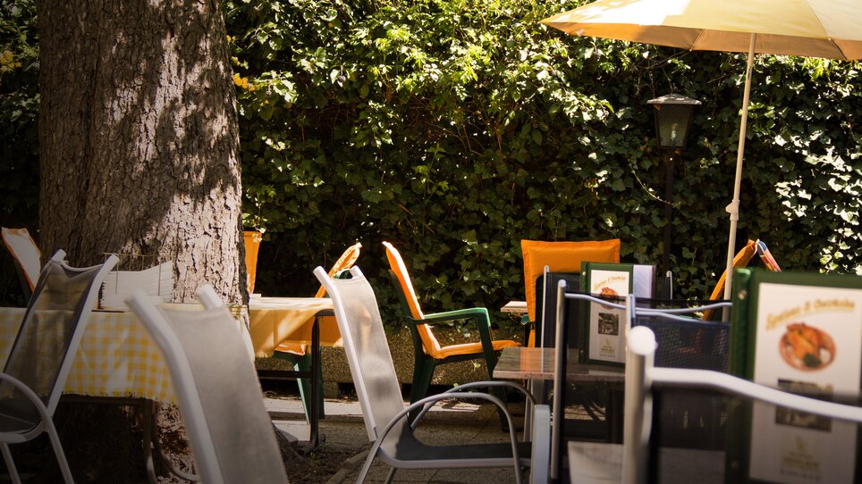 Terrasse mit Tischen und Stühlen im Freien, umgeben von Grün. | © Hotel Alter Telegraf