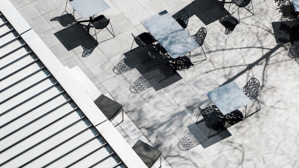 Stylische Tische und Stühle im Außenbereich des Augarten Art Hotels in Graz. | © Augarten Art Hotel