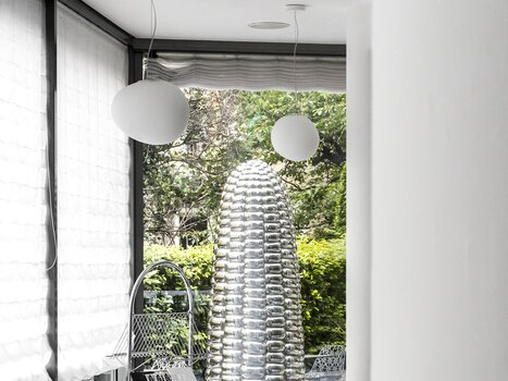 Un'area pranzo elegante con tavoli, lampade stilose e una scultura unica all'Augarten Art Hotel. | © Augarten Art Hotel