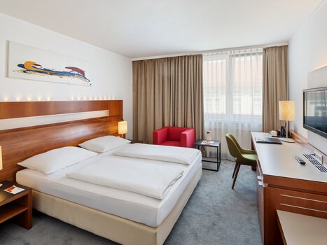 Una stanza dell'Austria Trend Hotel Europa a Graz con due letti, una scrivania e una TV. | © Austria Trend Hotel Europa