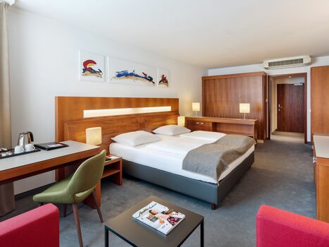 Vista di una camera d'albergo con letto matrimoniale e area salotto nell'Austria Trend Hotel Europa. | © Austria Trend Hotel Europa