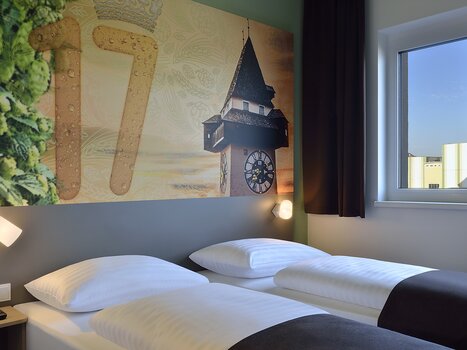 Zweibettzimmer mit Uhrturm-Motiv. | © B&B Graz City Süd