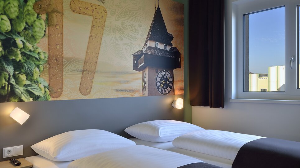 Zweibettzimmer mit Uhrturm-Motiv. | © B&B Graz City Süd