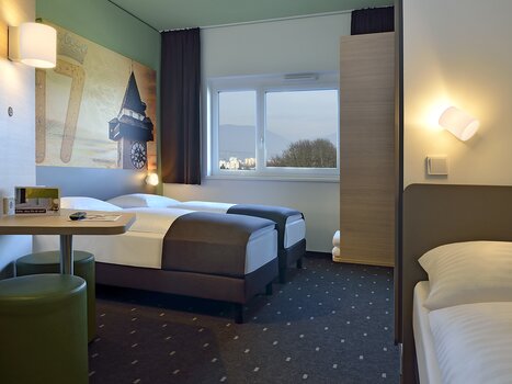 Zweibettzimmer mit extra Bett und Blick auf die Stadt. | © B&B Graz City Süd
