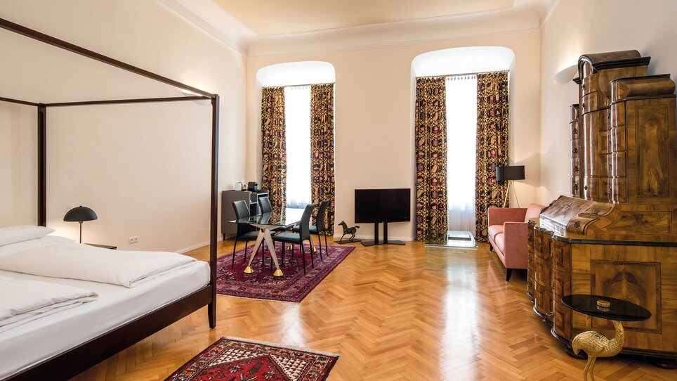 A spacious bedroom with a seating area and large windows. | © Robert Illemann