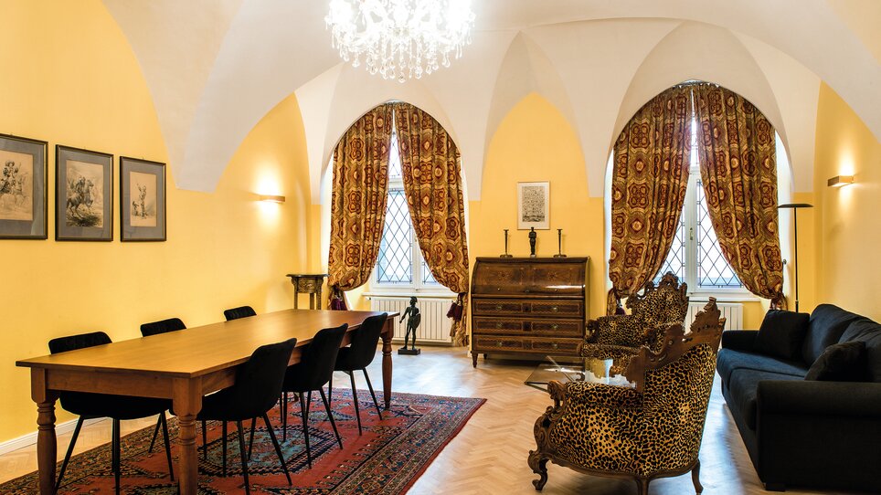 A historical room with yellow walls, antique furnishings, and a large chandelier. | © Robert Illemann