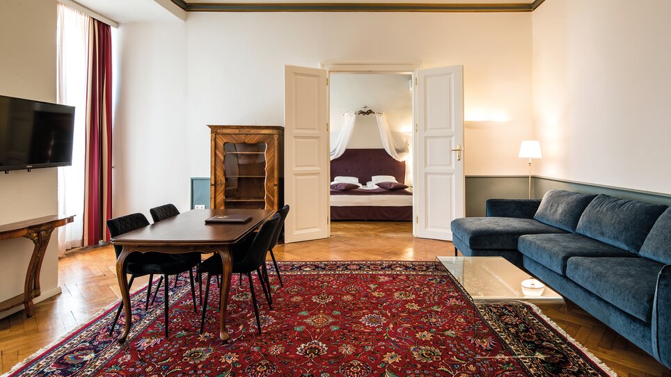 A spacious living area with table, chairs and view into the bedroom. | © Robert Illemann