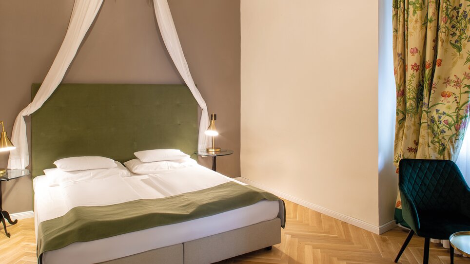 A stylish bedroom featuring two beds, bedside lamps, and a comfortable chair. | © Robert Illemann