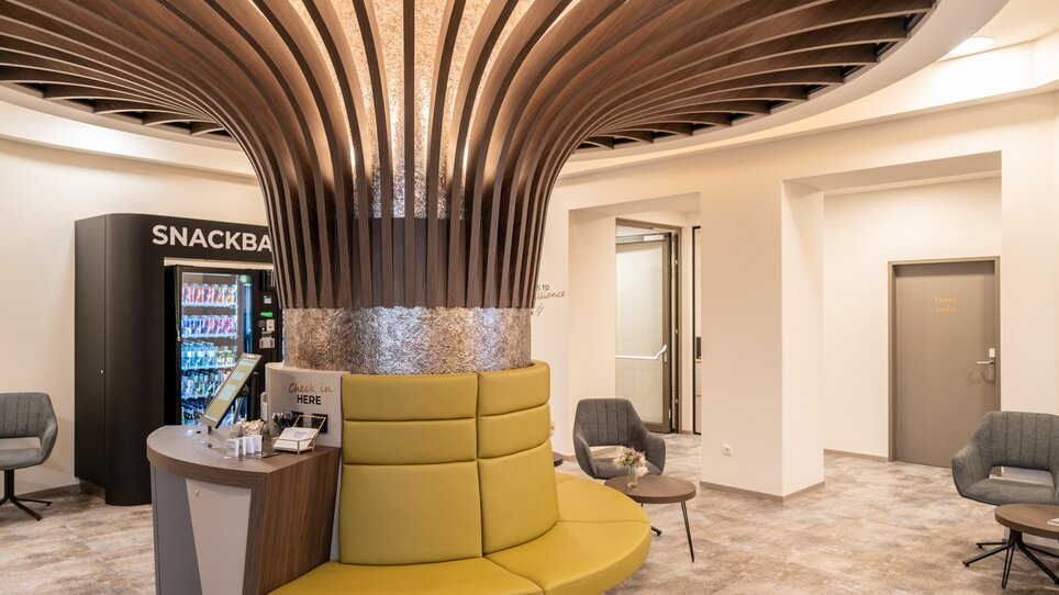 Interno con distributore automatico e area di seduta moderna. | © Chrizz Rooms
