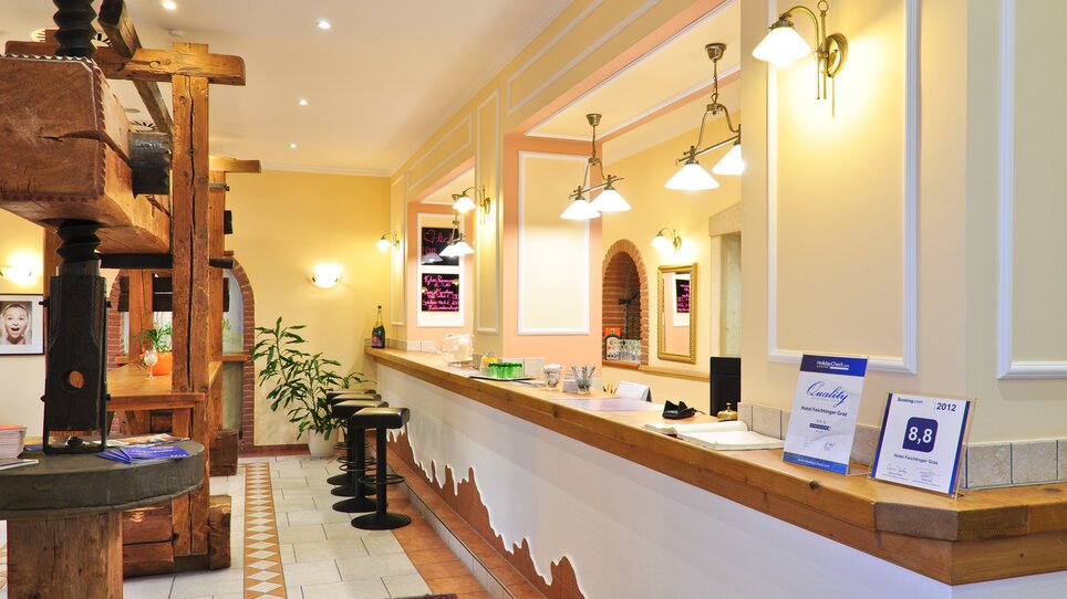 Farbenfrohe Rezeption im Hotel mit Stühlen und Pflanzen. | © Hotel Feichtinger