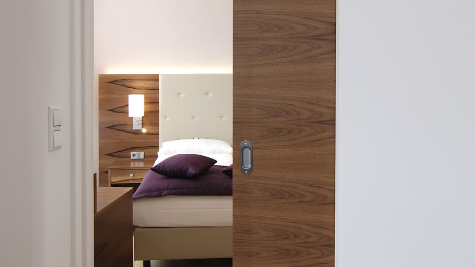 Ein Blick auf ein Schlafzimmer durch eine offene Tür. | © Hotel Feichtinger