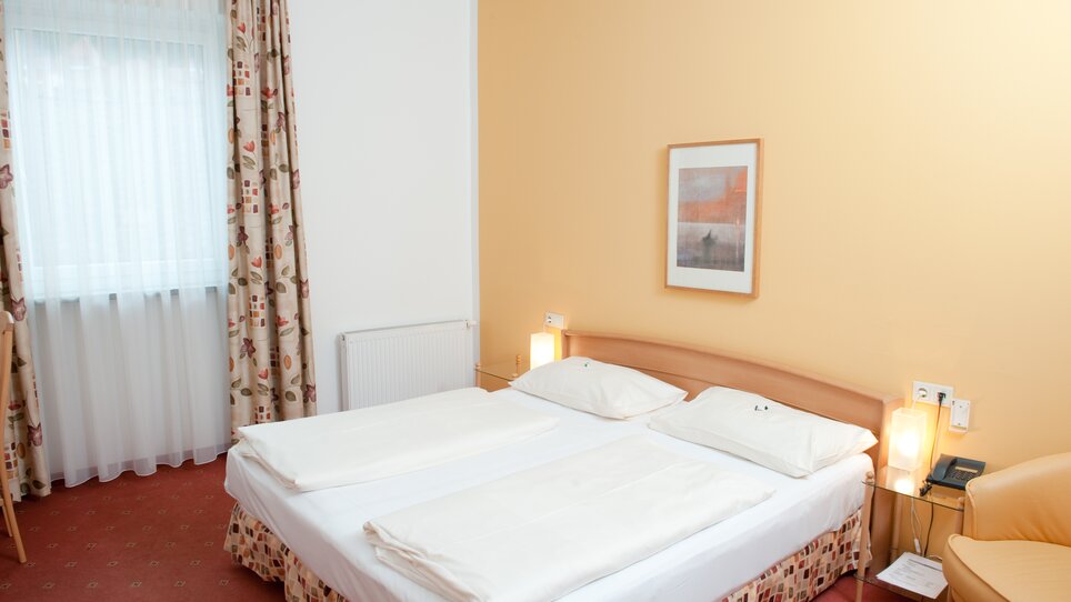 Ein einfaches Hotelzimmer mit zwei Betten und einem Fenster. | © Feichtinger