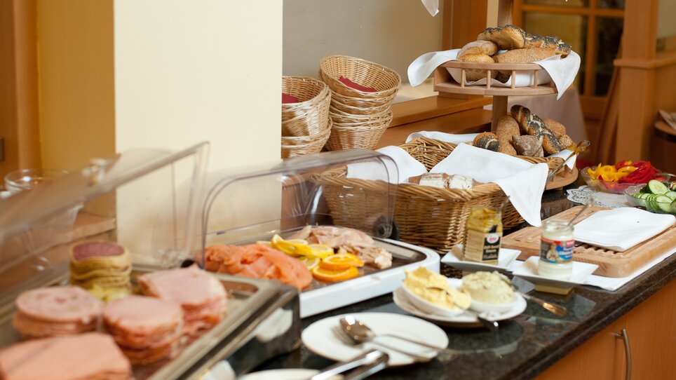 Vielfältiges Frühstücksbuffet mit Aufschnitt, Brötchen und Gemüse. | © Hotel Feichtinger