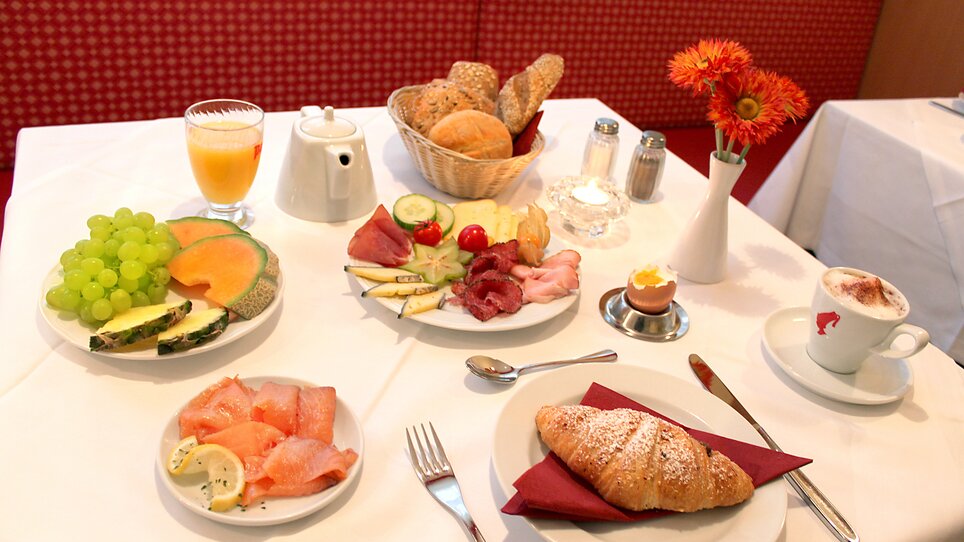 Ein reichhaltiges Frühstück mit Obst, Brot, Aufschnitt und Getränken auf einem Tisch. | © Hotel Feichtinger