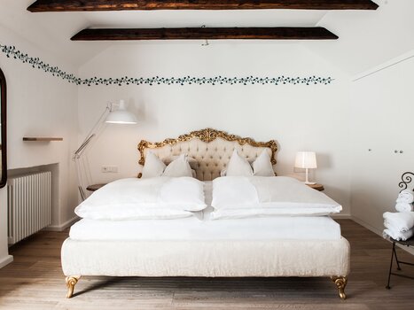 Elegant bedroom with a plush bed and stylish elements. | © Weitzer