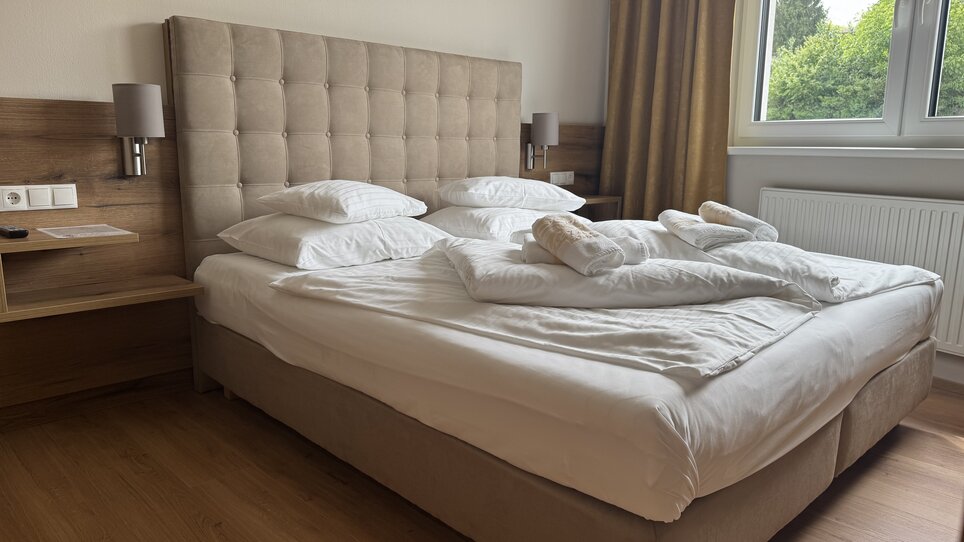 Bright room with a double bed, pillows, and a duvet. | © Der Marienhof