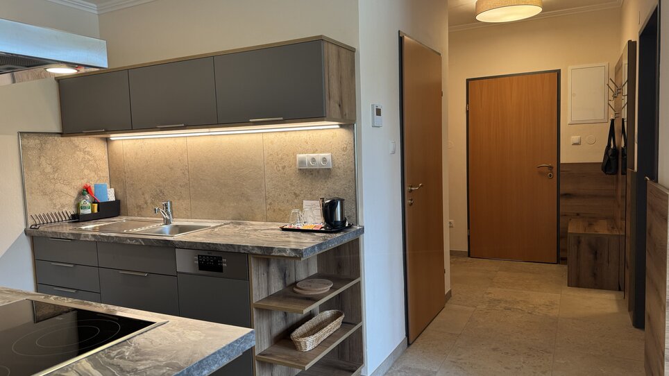 An image of a modern kitchen with a hallway in the background. | © Der Marienhof