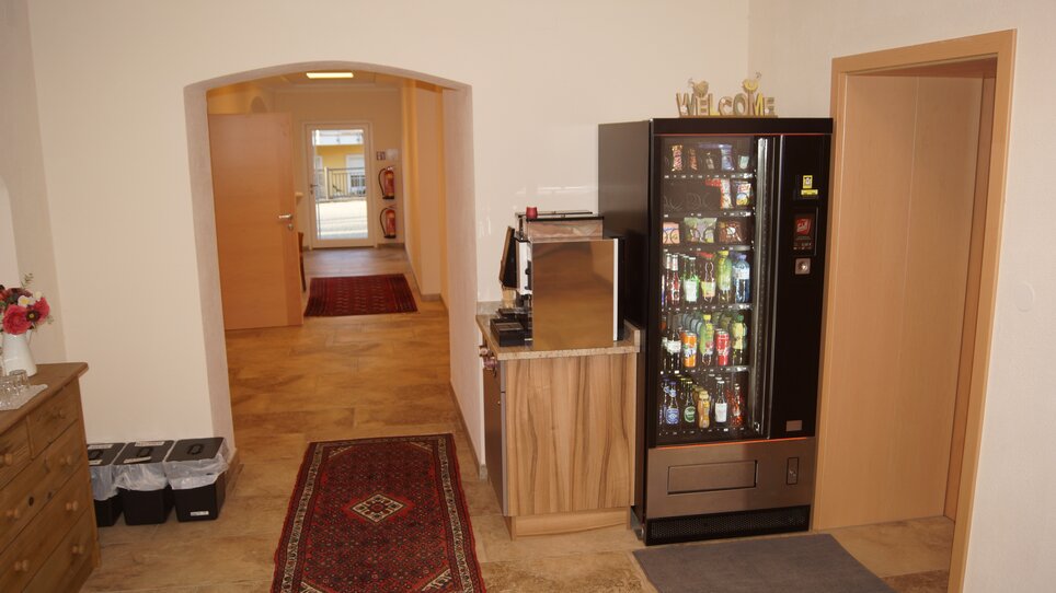 The entryway features a snack machine and a wooden cabinet. | © Der Marienhof