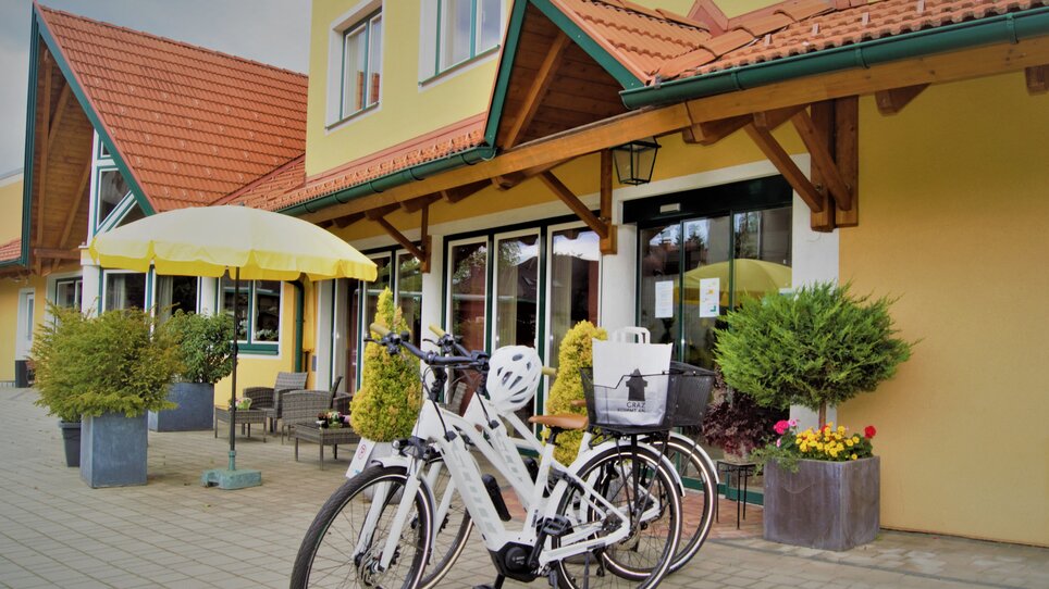 Two bicycles at the entrance of Hotel Garni der Marienhof with a yellow umbrella. | © Der Marienhof