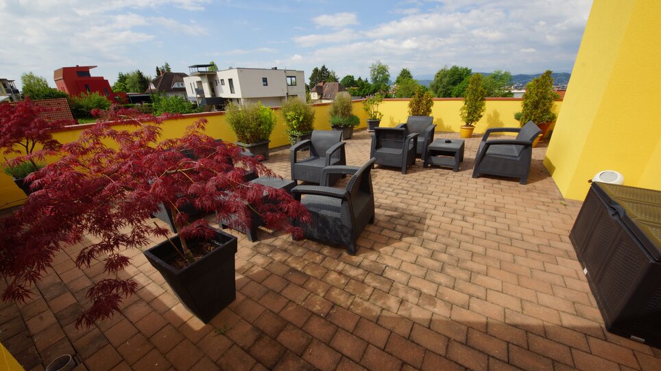 Cozy rooftop terrace featuring plants and comfortable seating. | © Der Marienhof