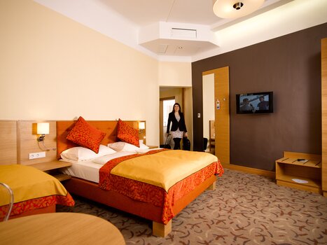 Bright hotel room with two beds and a TV. | © Hotel Drei Raben