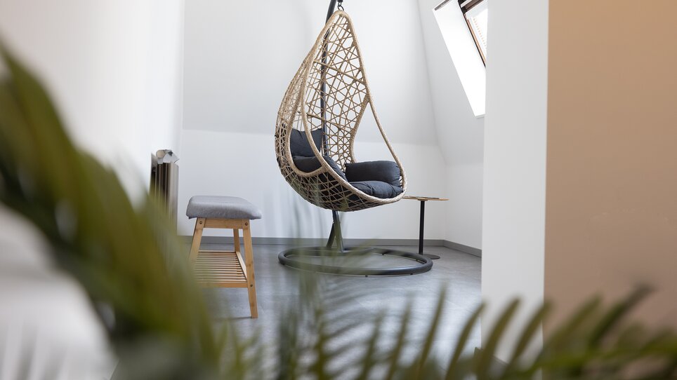 Hängesessel aus Rattan in einem hellen Raum. | © Hotel Gollner
