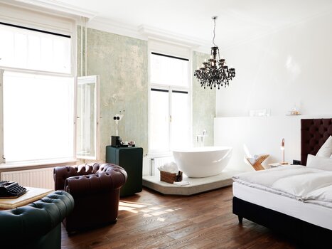 Una camera d'hotel elegante con vasca freestanding e decorazioni raffinate.