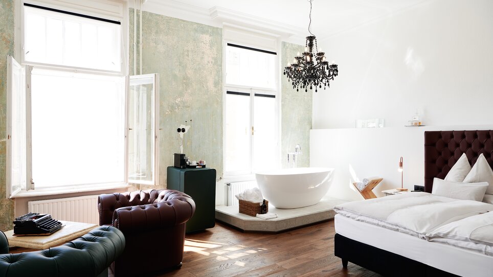 Ein stilvolles Hotelzimmer mit freistehender Badewanne und eleganter Einrichtung.