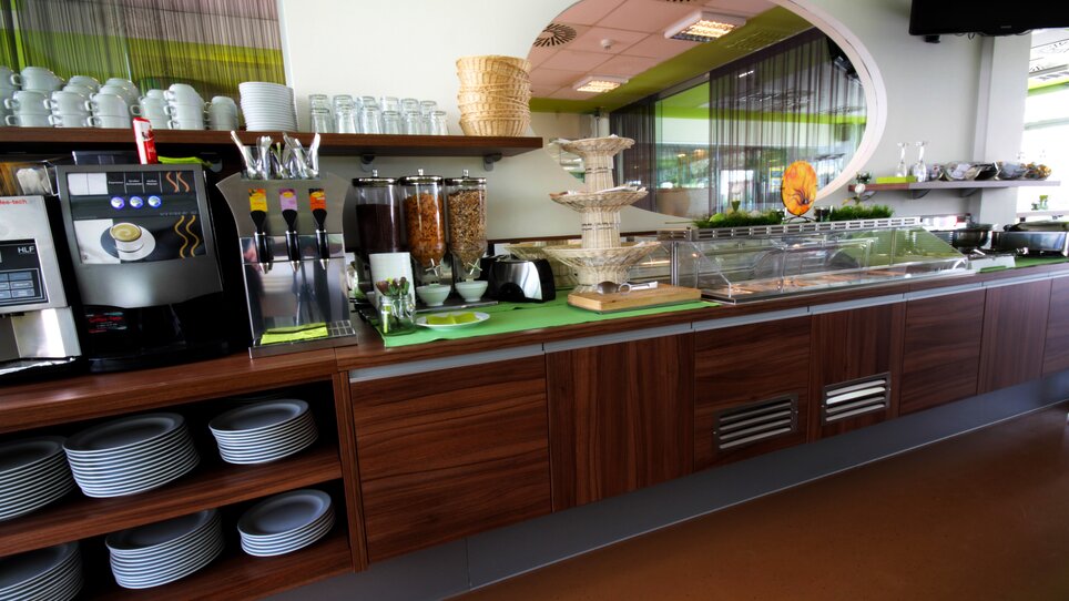 Un'area buffet con vari cibi, bevande e stoviglie. | © Hotel Greenrooms