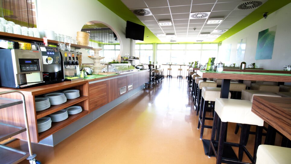 Panoramica del ristorante con tavoli, bar e macchina da caffè. | © Hotel Greenrooms