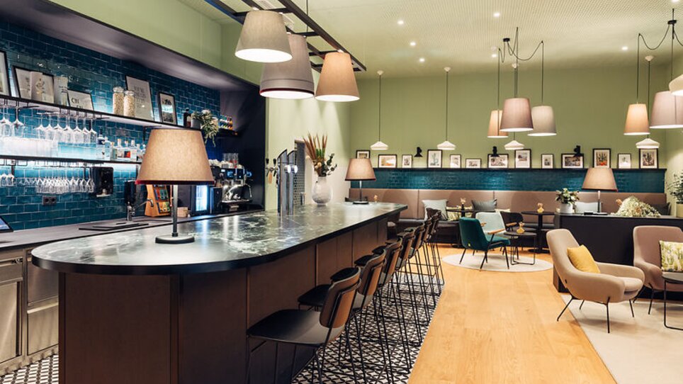 Area d'ingresso di un caffè con bar e posti a sedere nell'harry's home Graz-Smart City. | © harry's home Graz-Smart City- Daniel Zangerl