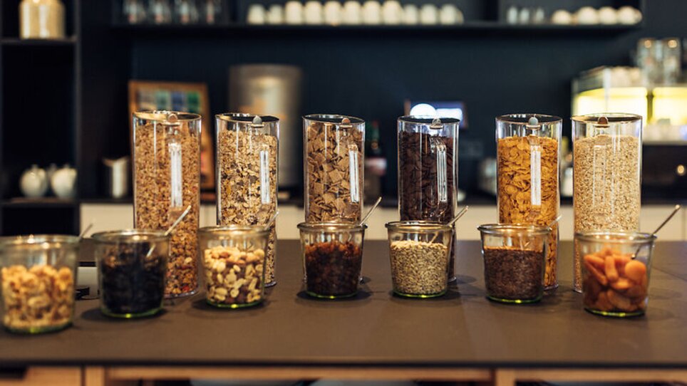Vasi pieni di cereali e snack su un tavolo in harry's home Graz-Smart City. | © harry's home Graz-Smart City - Daniel Zangerl