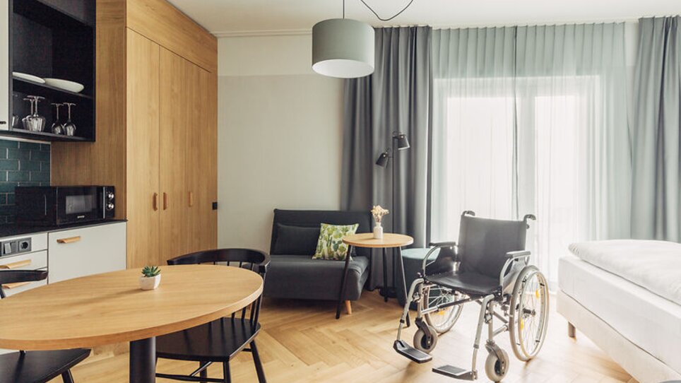 Interno di una camera accessibile con una sedia a rotelle al'harry's home Graz-Smart City. | © harry's home Graz-Smart City- Daniel Zangerl